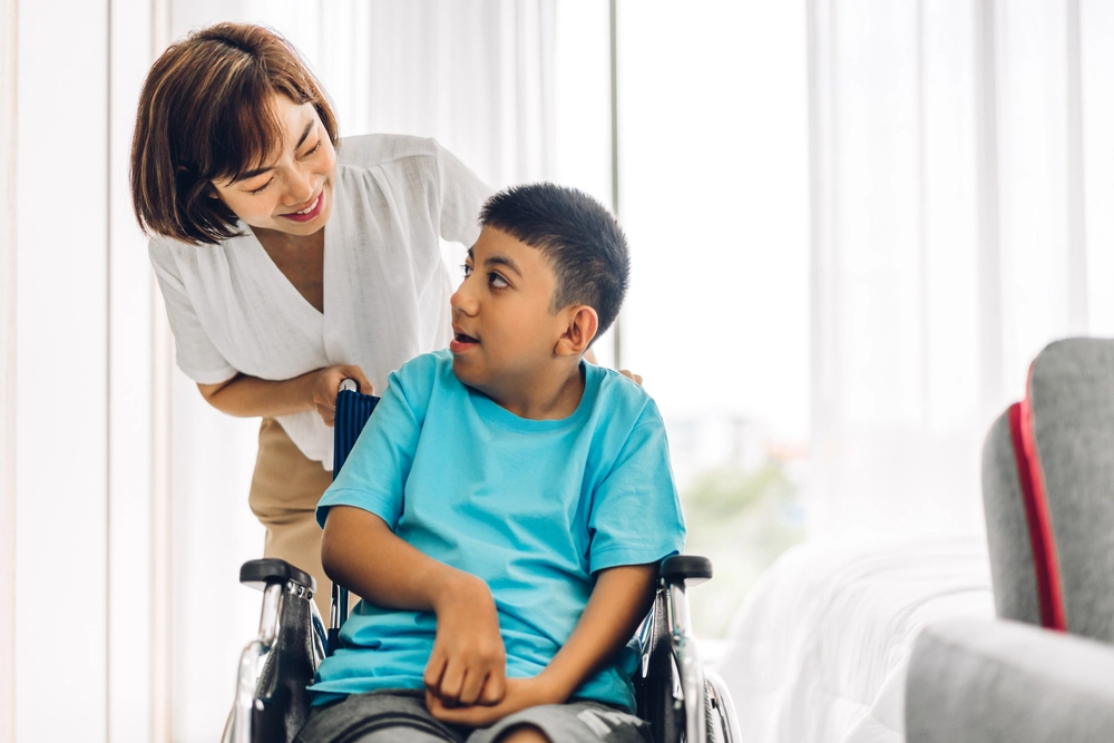 nurse with a young disabled boy on wheelchair