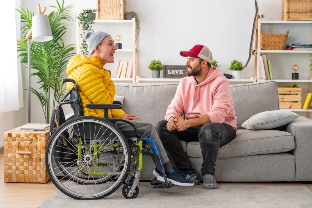 care taker with disabled boy on wheelchair, down syndrome disability