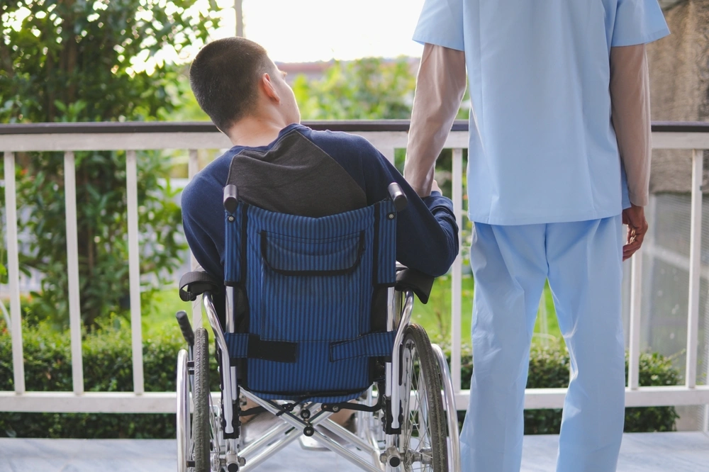 nurse with disabled young boy on wheelchair